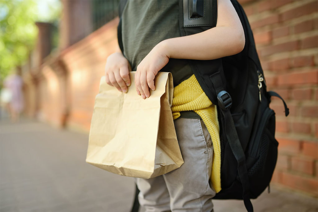 Boy carrying a bagged lunch